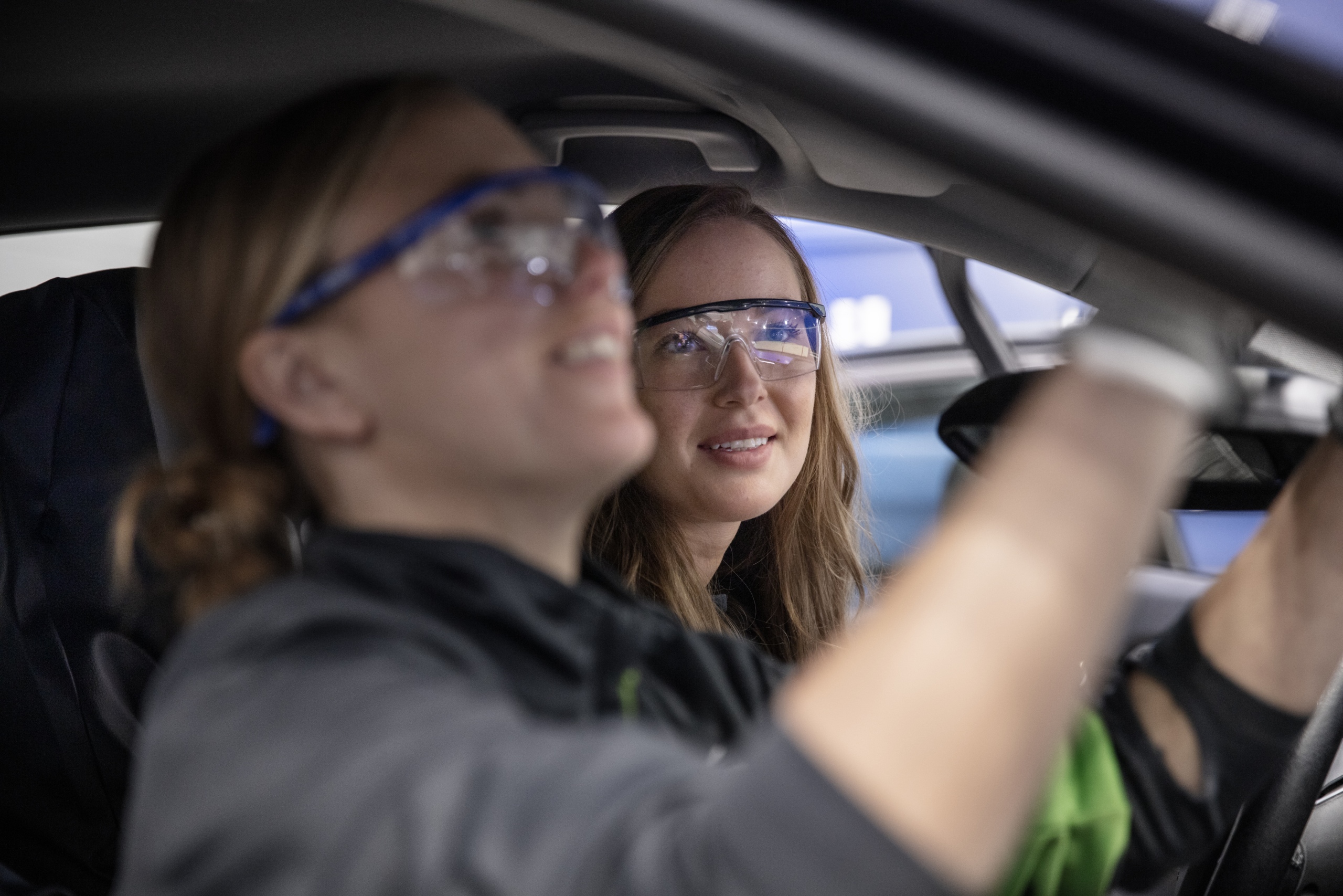 Två Ryds anställda kvinnor sitter och arbetar på insidan av en bil